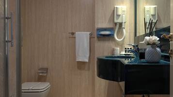 A modern bathroom with a toilet, sink, and shower area.