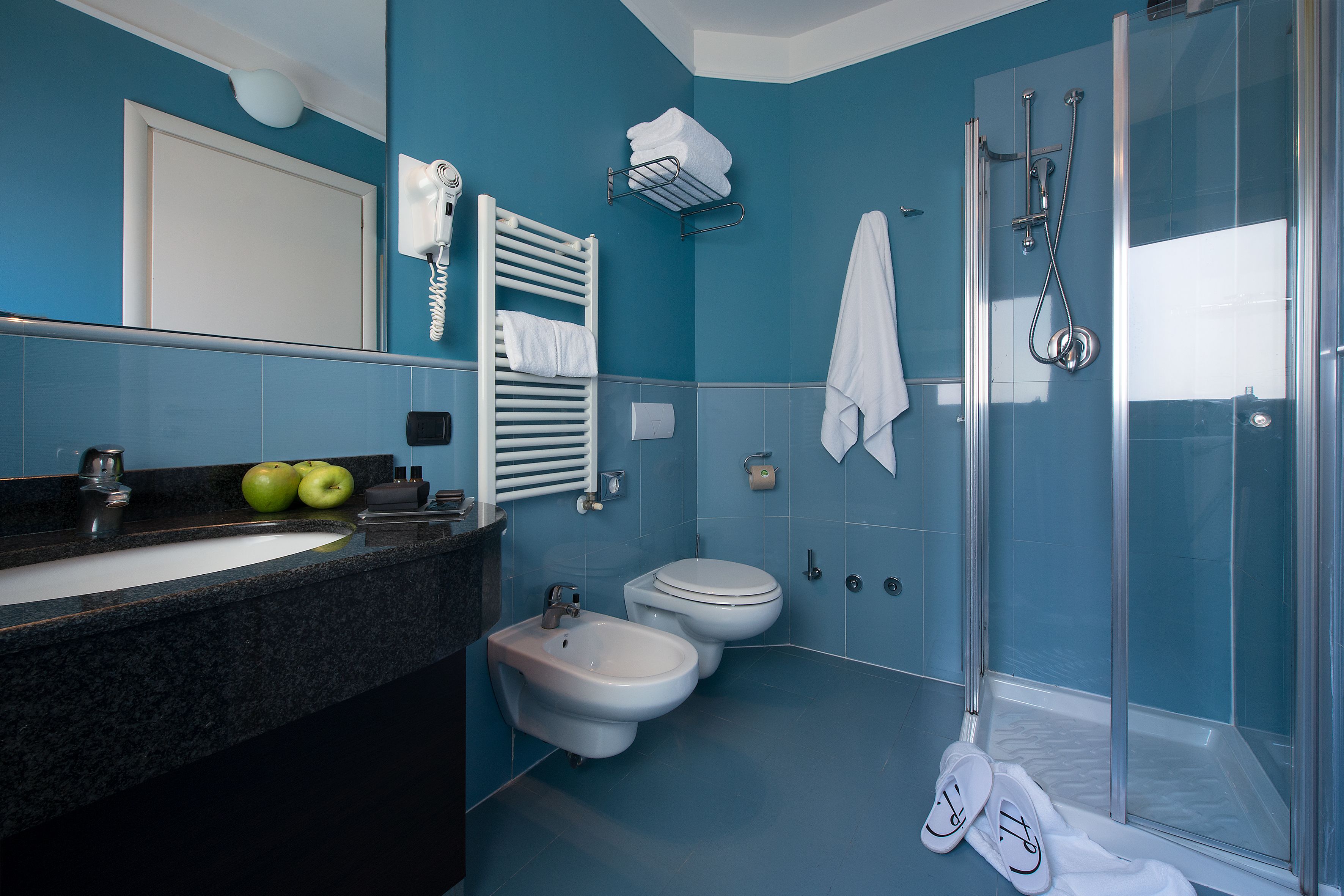 Une salle de bain équipée d’un lavabo, d’un bidet, de toilettes et d’une douche à parois de verre.