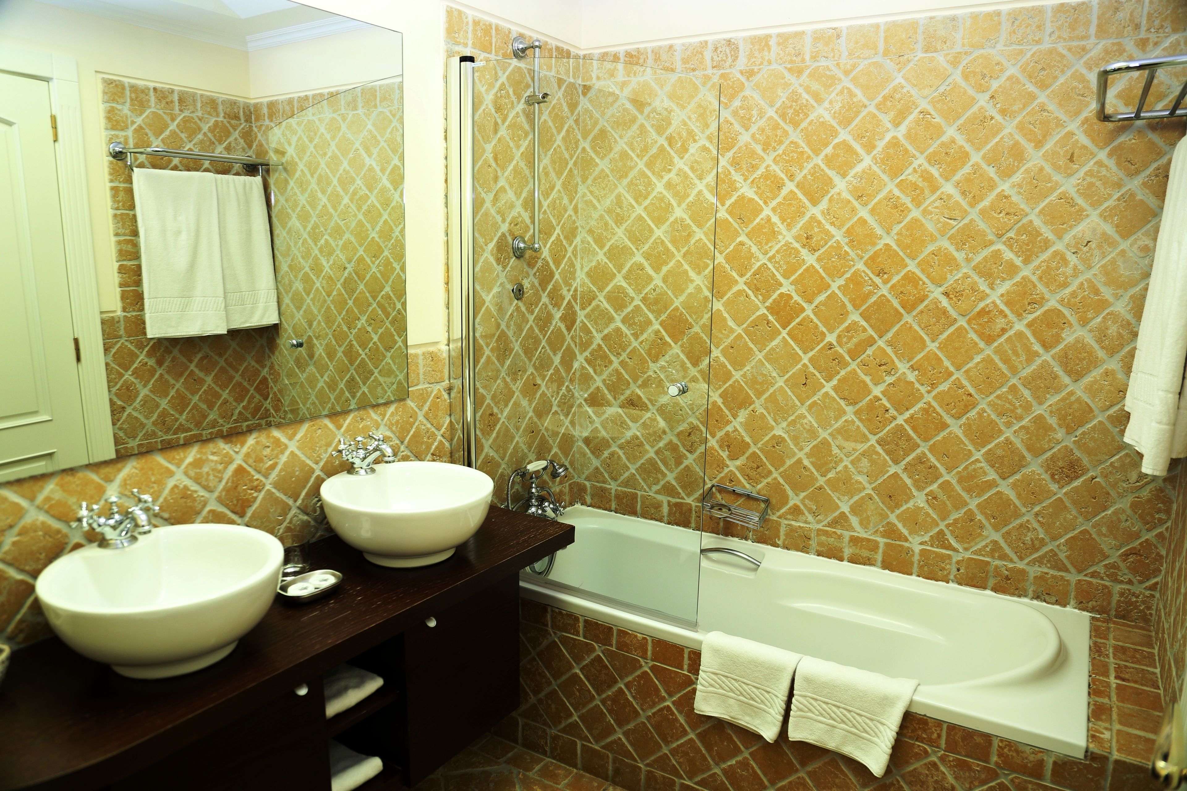 Ein Badezimmer mit zwei Waschbecken, einer Badewanne und einer Dusche.