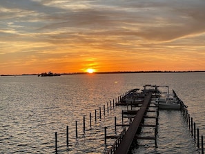 A pier extending into calm water with a sunset in the background. - Beso Del Sol Resort (Dunedin)