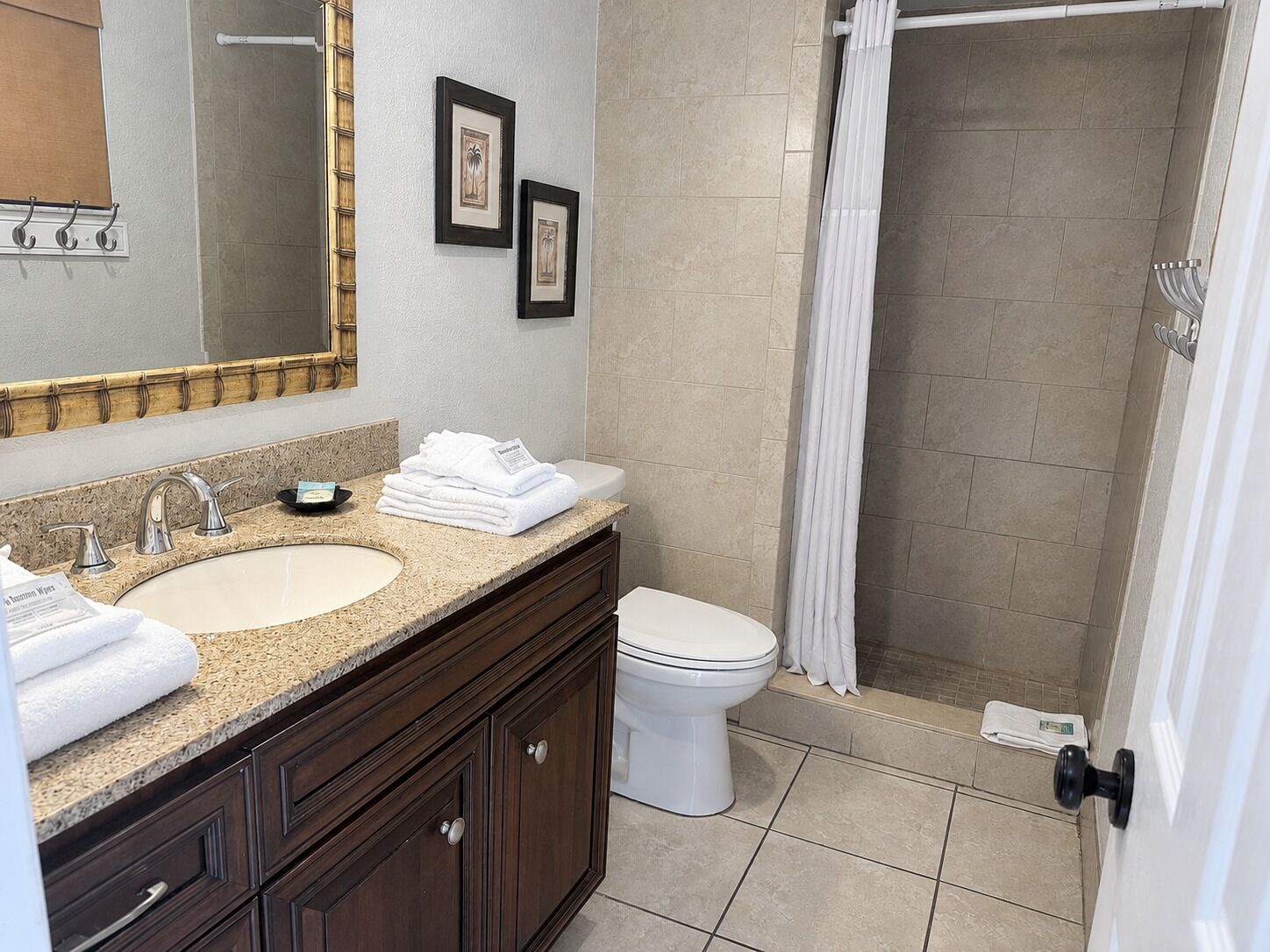 A bathroom with two sinks, a toilet, and a shower.