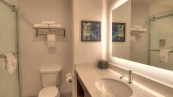 Ein modernes Badezimmer mit Toilette, Waschbecken und Duschkabine aus Glas.