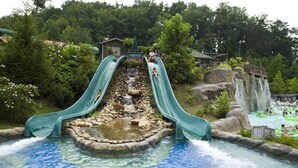 A water park with two slides, a rocky waterfall, and a pool area. - Holiday Inn & Suites Pigeon Forge Convention Center by IHG (Pigeon Forge)