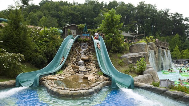A water park with two slides, a rocky waterfall, and a pool area. - Holiday Inn & Suites Pigeon Forge Convention Center by IHG (Pigeon Forge)