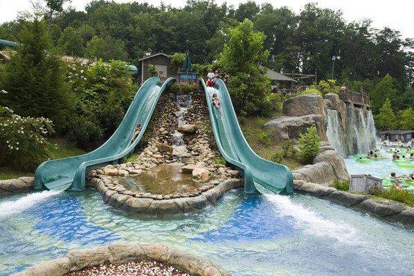 A water park with two slides, a rocky waterfall, and a pool area. - Holiday Inn & Suites Pigeon Forge Convention Center by IHG (Pigeon Forge)