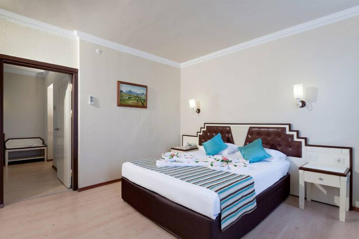 A bedroom with a bed, bedside table, and a mirror.
