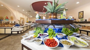 A buffet with various food items and a decorative centerpiece. - Nova Park (Manavgat)