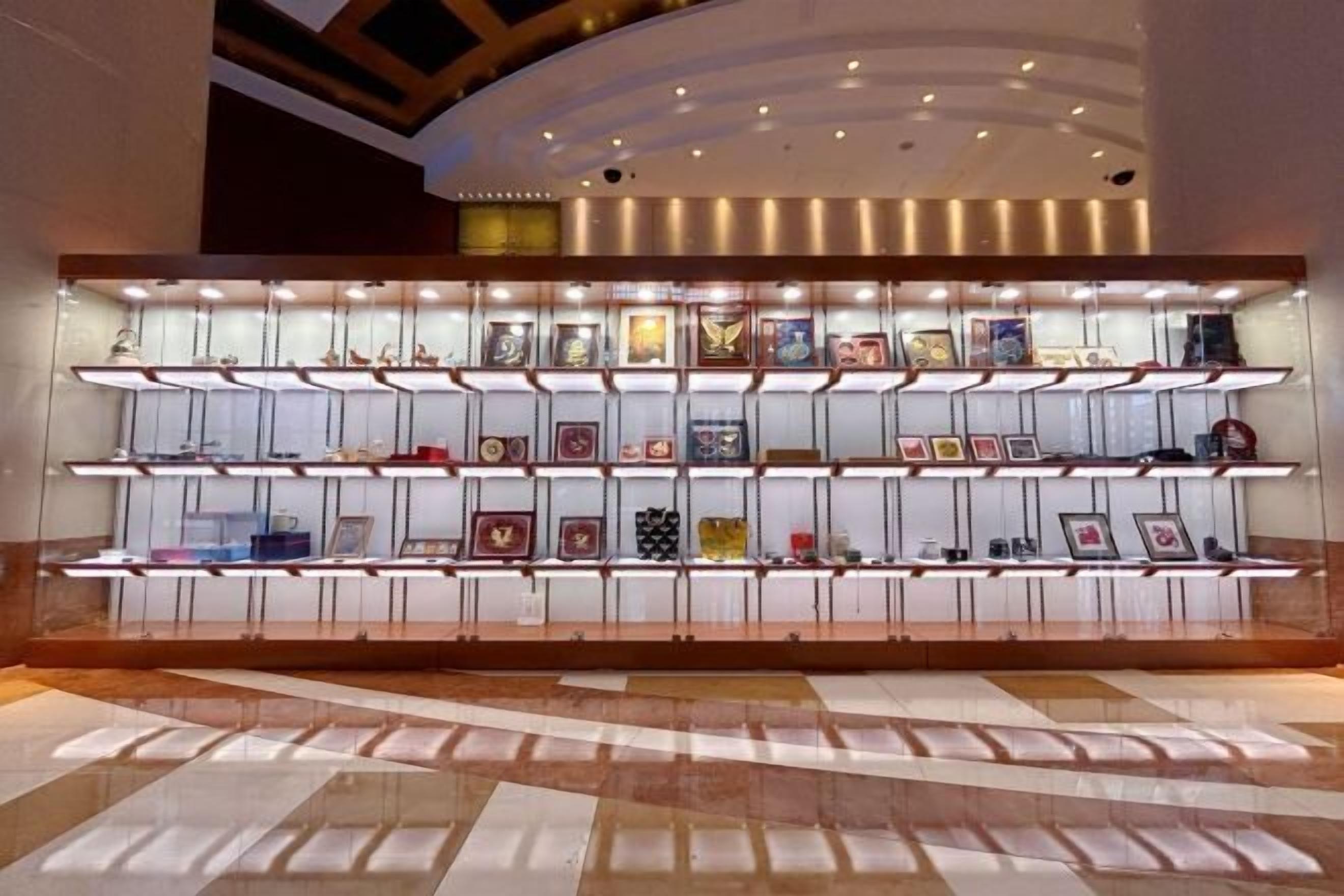 A display of framed items on shelves in a lobby area.