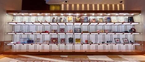 A display of framed items on shelves in a lobby area.