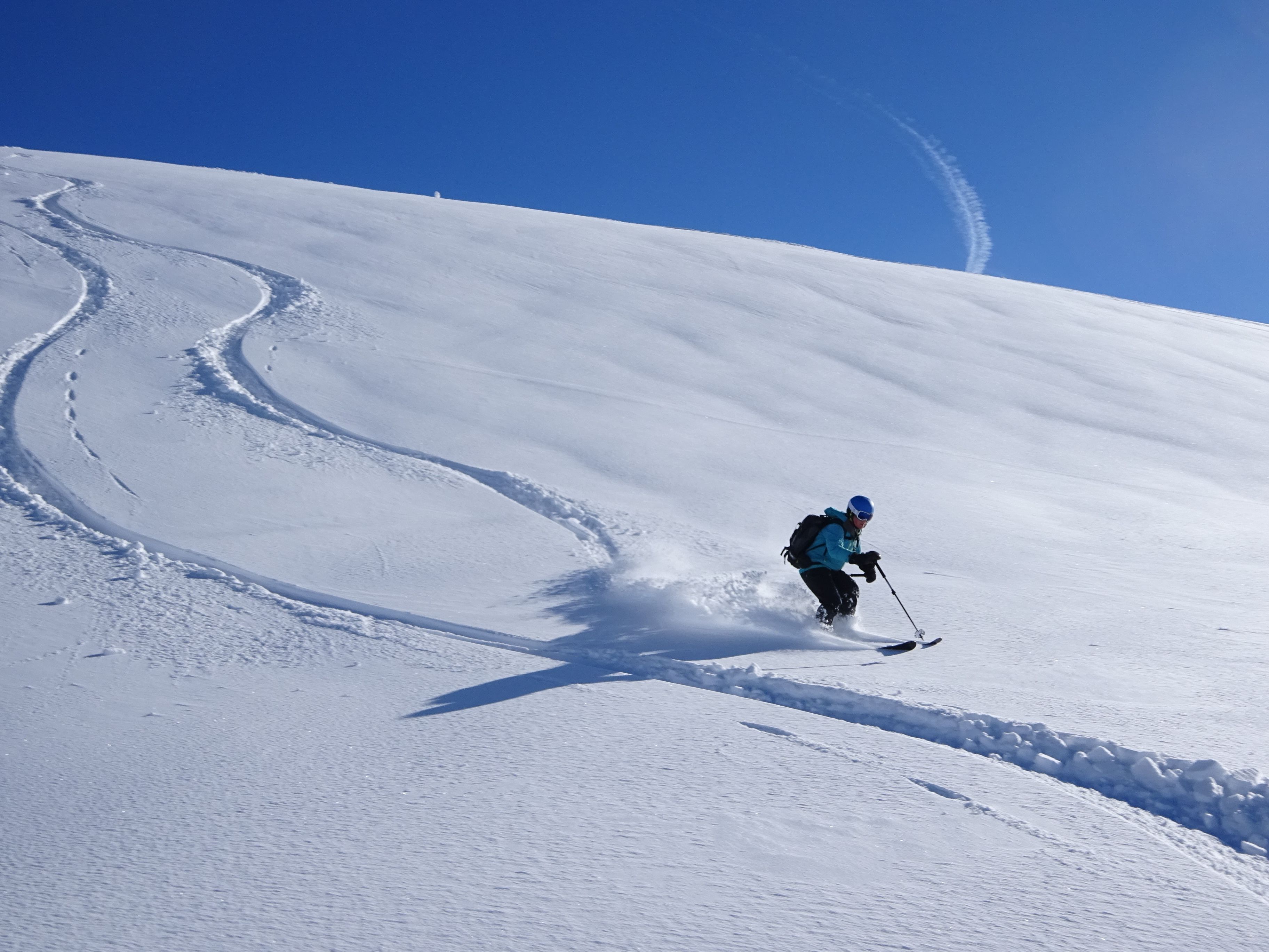 Une personne qui fait du ski sur une pente enneigée.