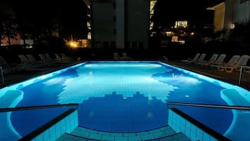 Una piscina al aire libre de temporada, sillones reclinables de piscina