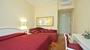 Ein Hotelzimmer mit einem großen Bett, einem Schreibtisch mit Stuhl, einem Spiegel und einer Tür.