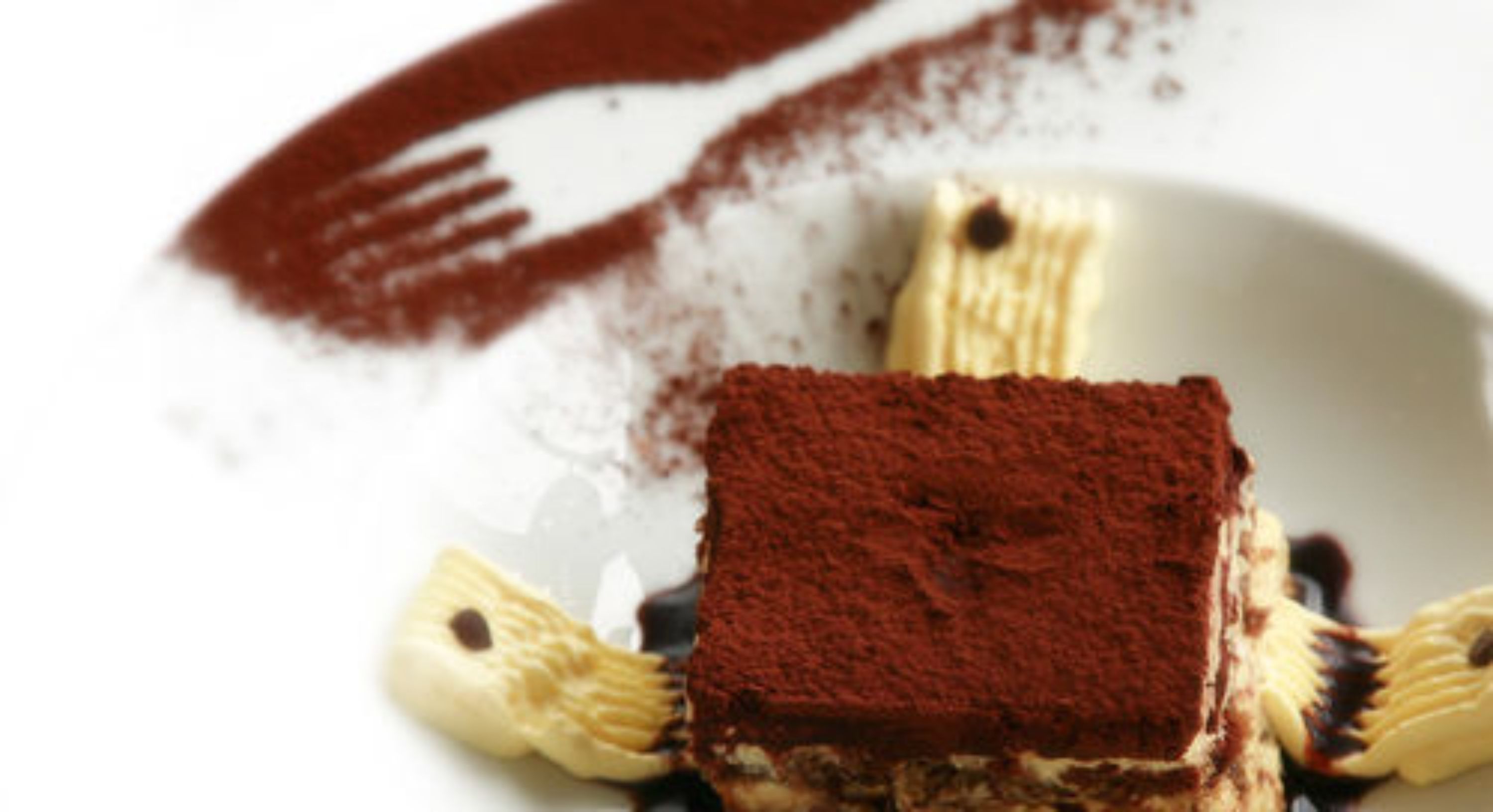 A dessert with a chocolate base and caramelized bananas on a white plate.