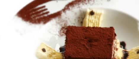 A dessert with a chocolate base and caramelized bananas on a white plate.