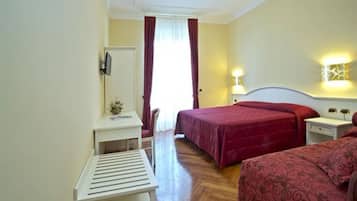Ein Hotelzimmer mit Bett, Schreibtisch, Stuhl und Nachttisch.