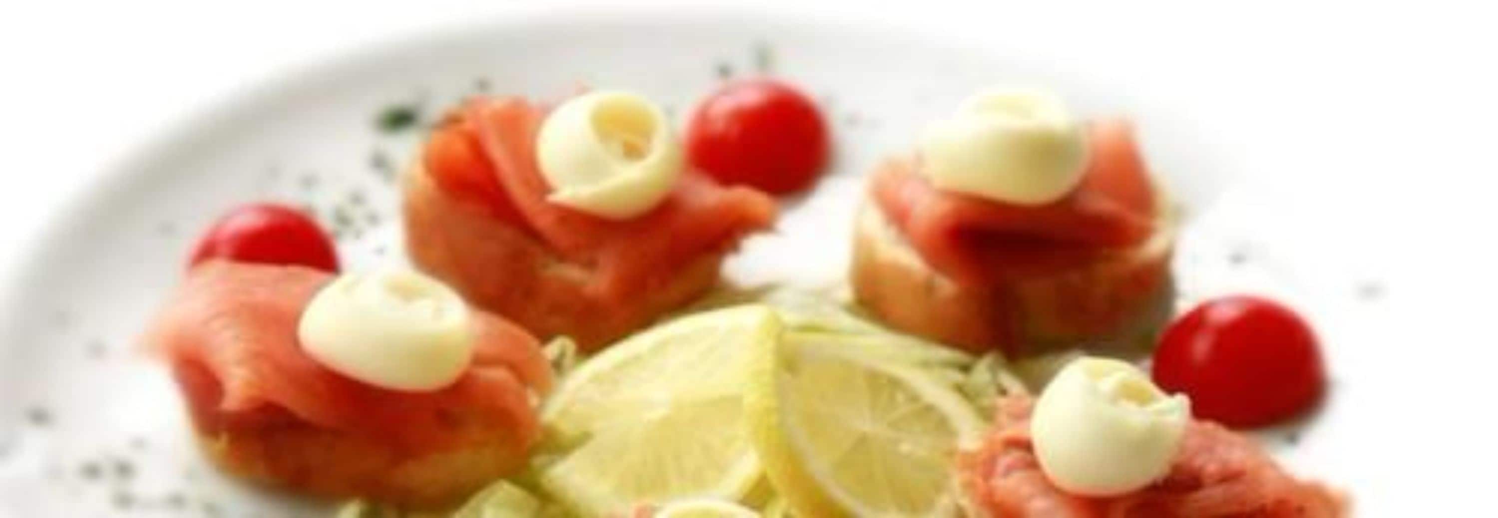 A plate with food items including salmon, cherry tomatoes, and a lime wedge.