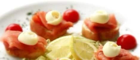 A plate with food items including salmon, cherry tomatoes, and a lime wedge.