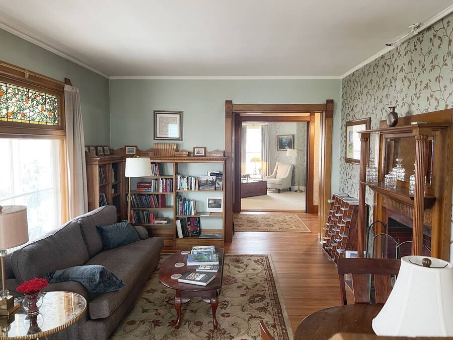 A cozy living room with a sofa, coffee table, bookshelves, and a fireplace.