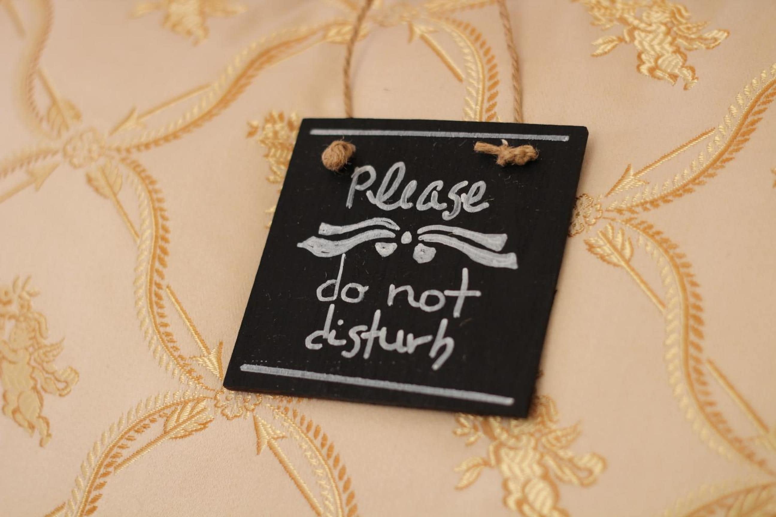 A black sign with white text on a beige fabric background.