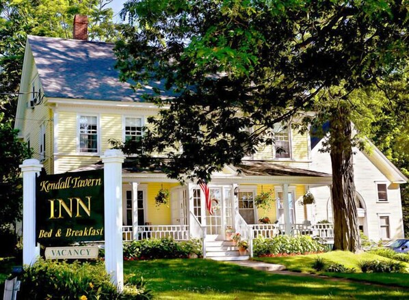 A yellow building with a sign reading "Kendall Tavern Inn Bed & Breakfast" and a "VACANCY" sign.