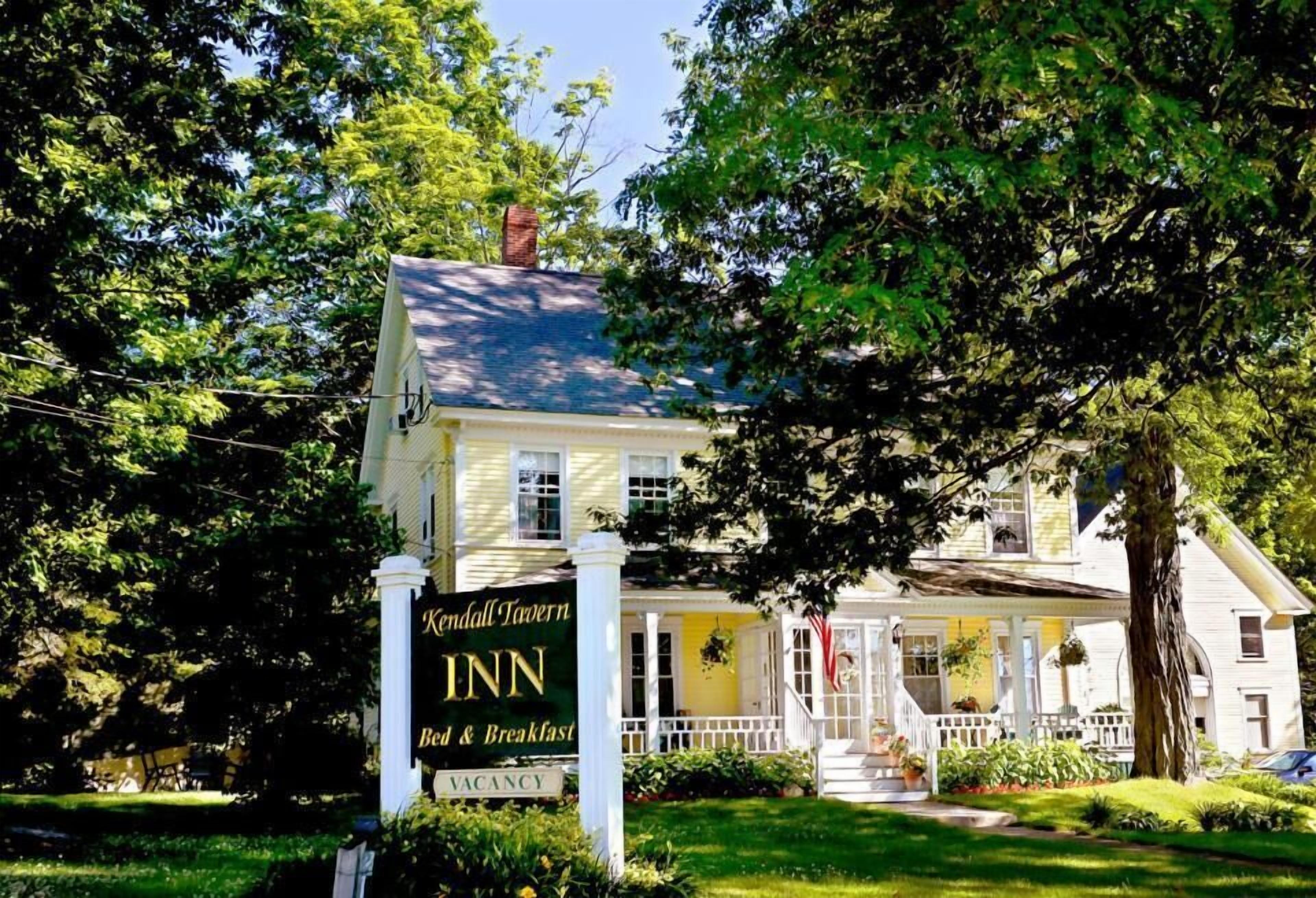 A yellow building with a sign reading "Kendall Tavern Inn Bed & Breakfast" and "VACANCY".