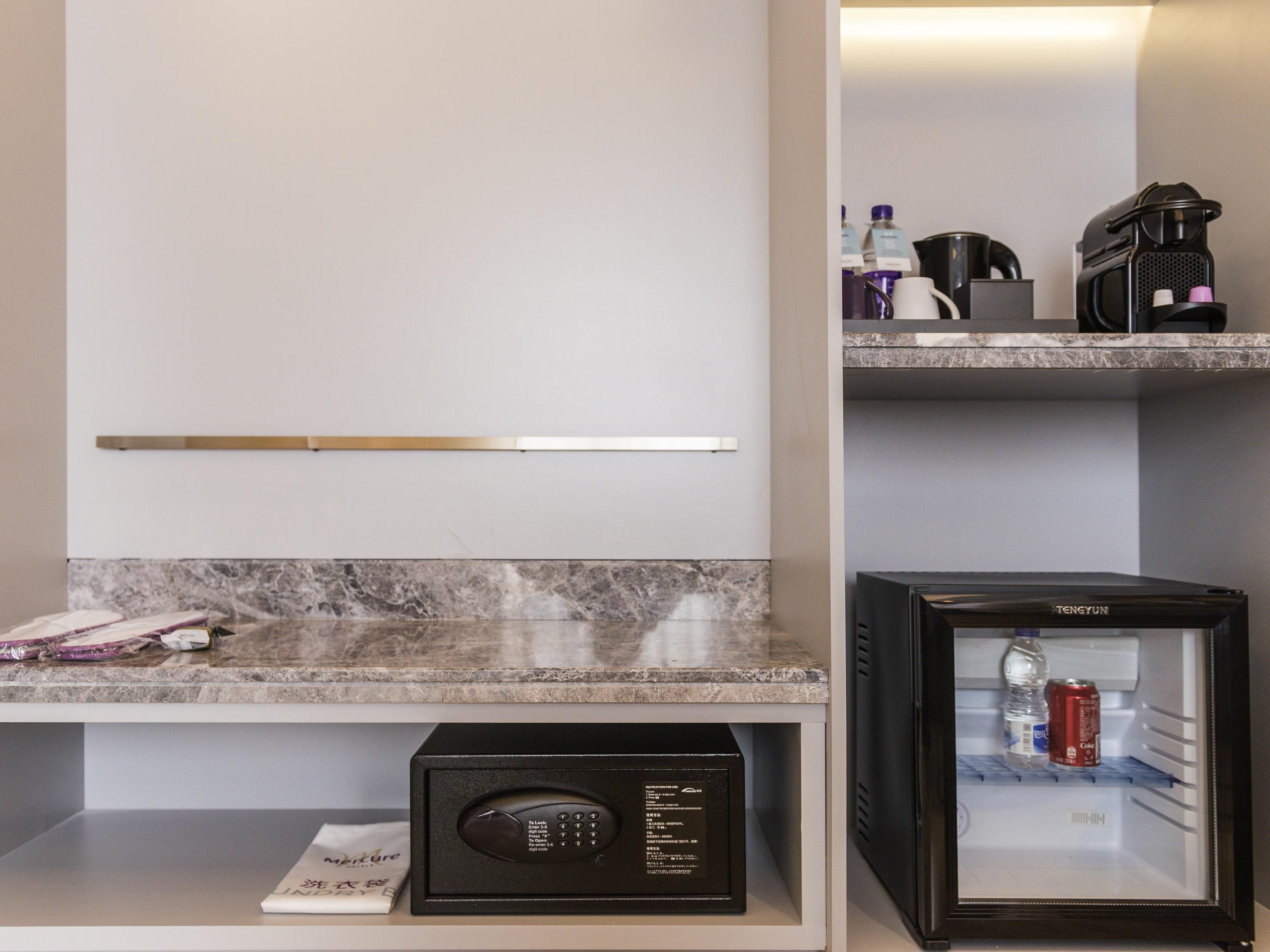 A modern kitchen with a marble countertop, a coffee machine, a refrigerator, and a microwave.