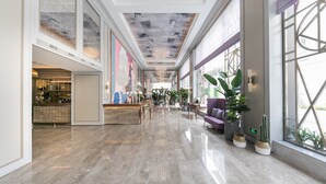 A spacious lobby with a high ceiling, a reception desk, seating area, and large windows. - Mercure Xi'an Downtown (Xi'an)