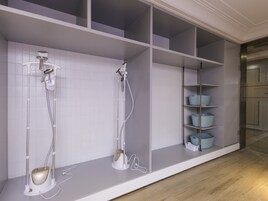 Un baño con ducha, un perchero y estantes de almacenamiento.
