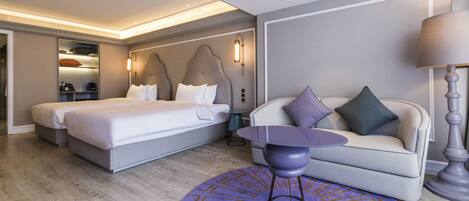 Una camera d'albergo con un letto, un divano, un tavolino e un tappeto decorato.