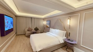 A hotel room with a large bed, a sofa, a TV, and a small table. - Mercure Xi'an Downtown (Xi'an)
