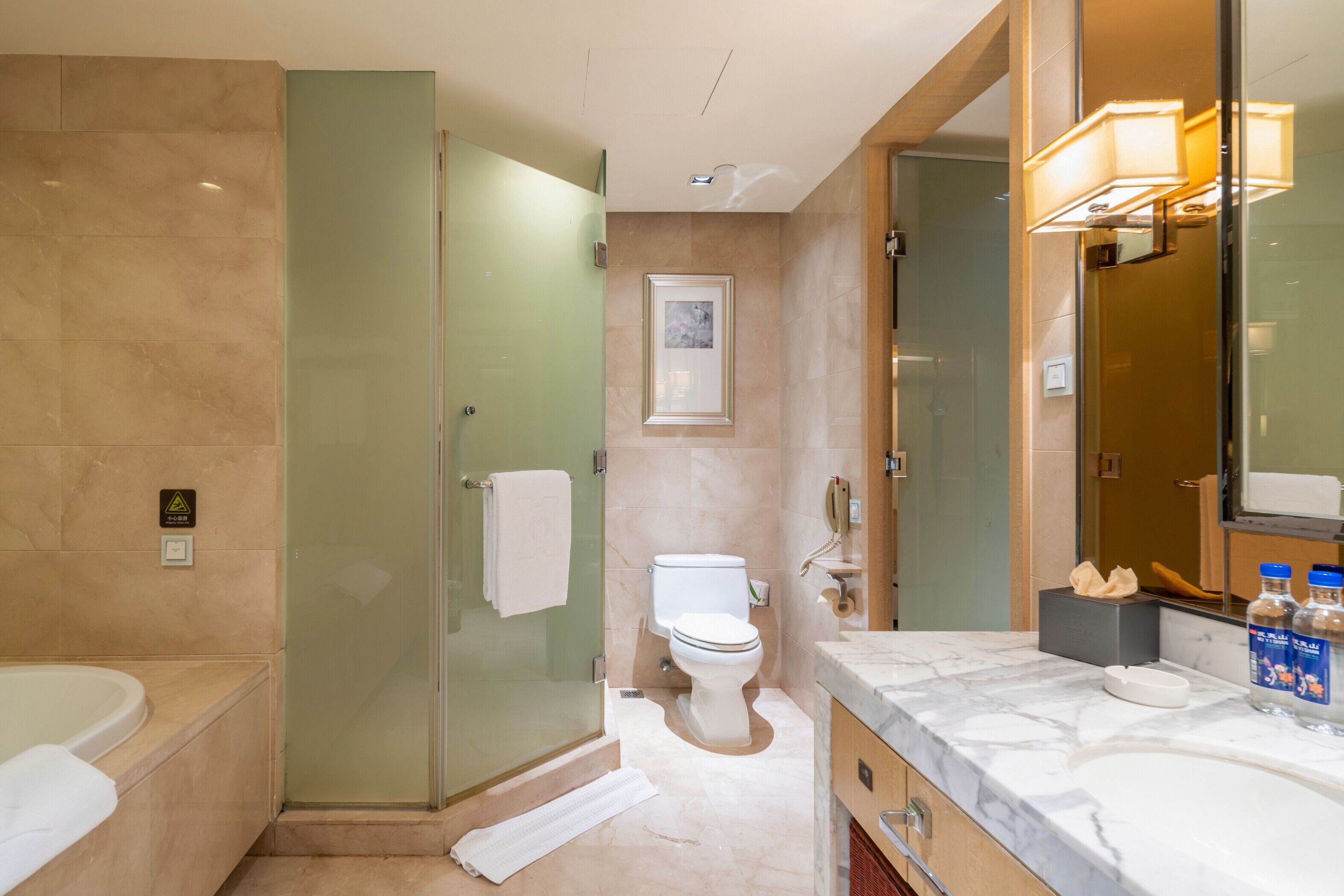 Un bagno moderno con doccia vetrata, un water, una vasca e un mobile lavabo con specchio.