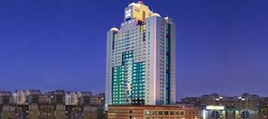 Un hotel de gran altura con varios pisos, una torre central destacada y un techo plano.