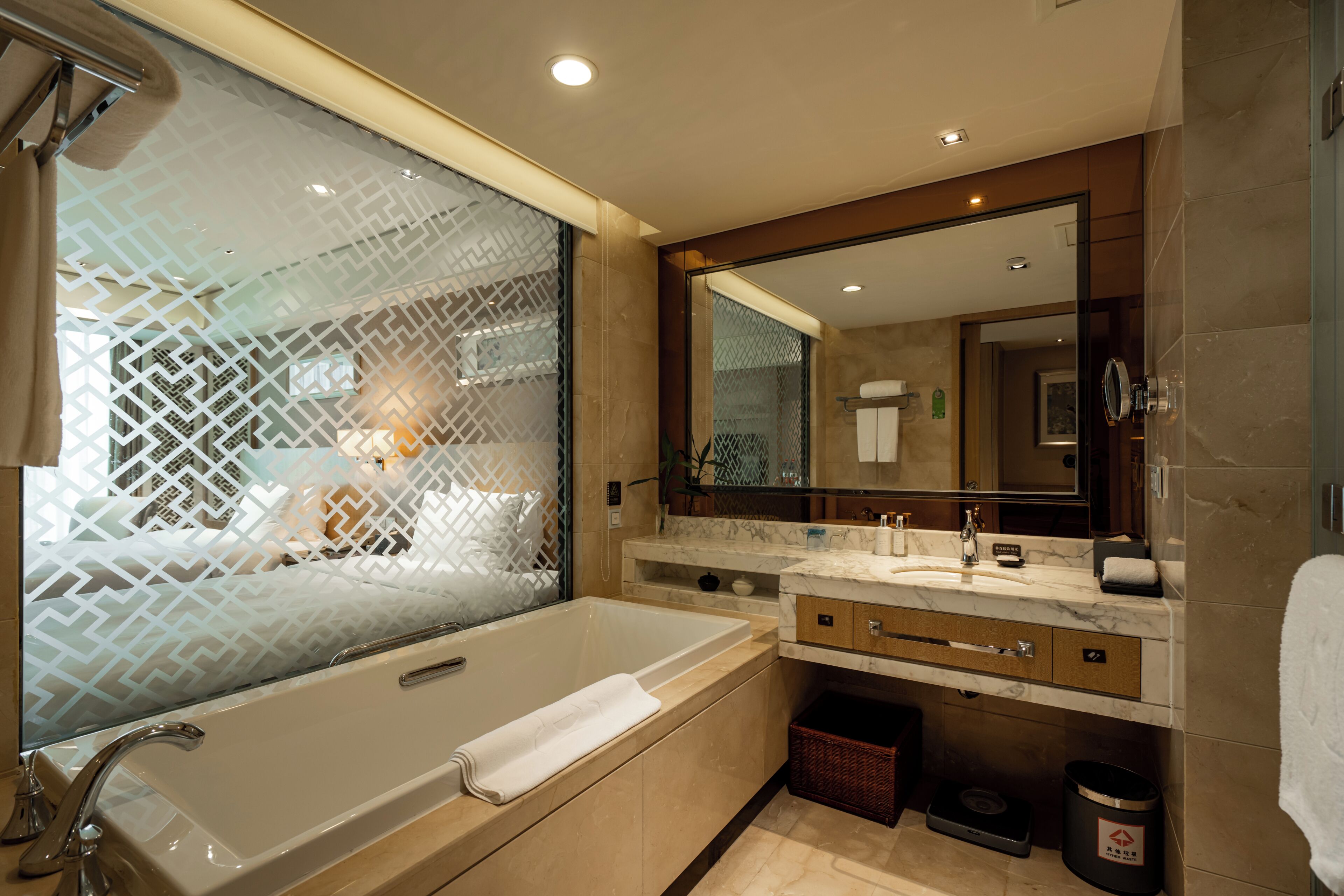 A modern bathroom with a large bathtub, a vanity with a mirror, and a shower area.