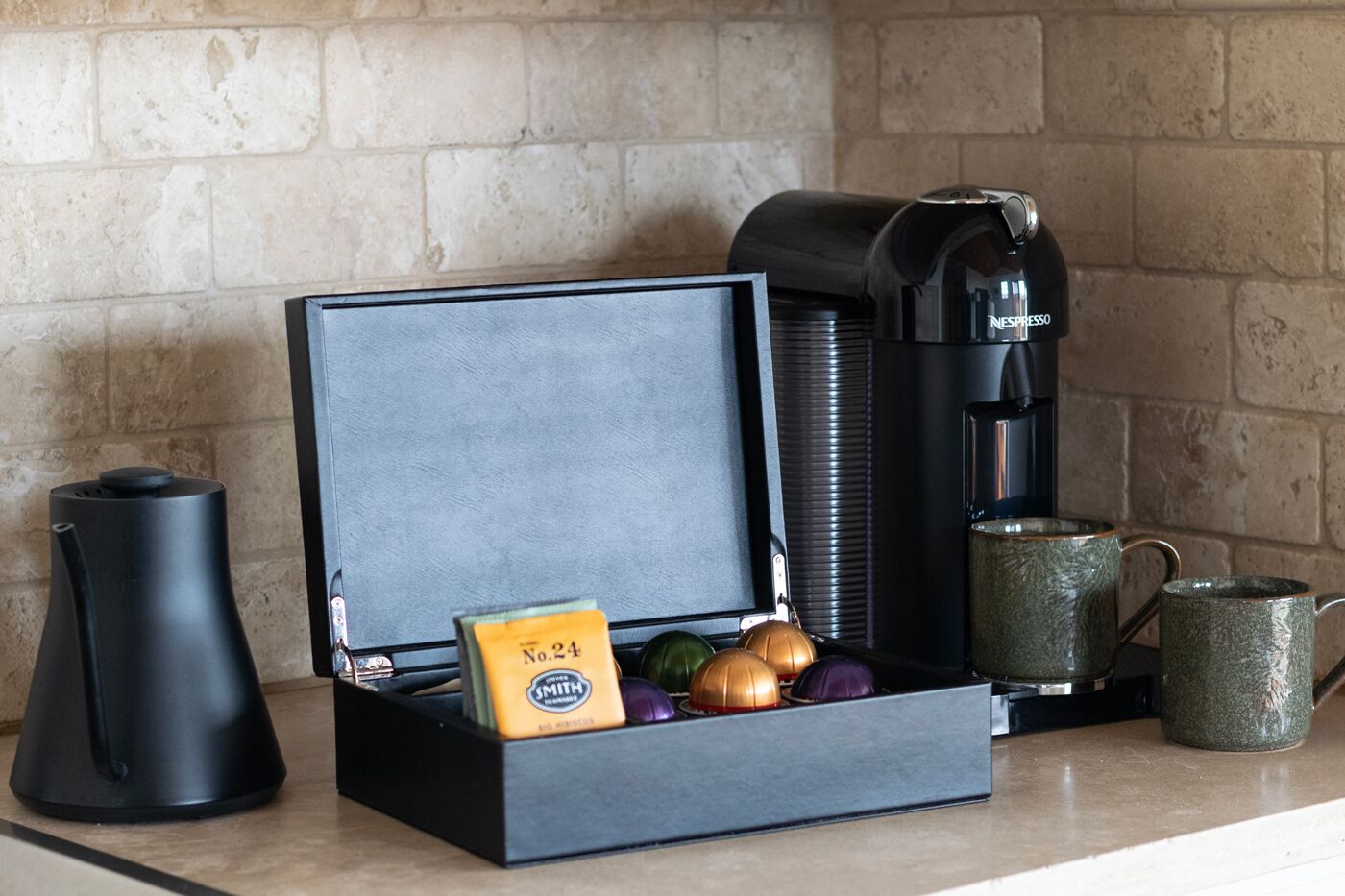Eine Küchenarbeitsplatte mit Kaffeemaschine, einer Packung Smith Kaffeebohnen, einer Kaffeemühle und einer grünen Tasse.