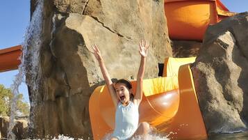 Enjoy a thrilling water slide experience amidst a natural rock formation.