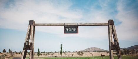 Ein hölzerner Bogen mit einem Schild, auf dem 'BRASADA RANCH' steht.