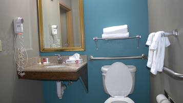 A bathroom with a sink, mirror, towel rack, and toilet.