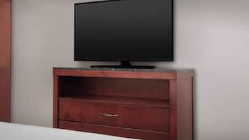 Televisor de pantalla plana fixat en un armari de fusta amb un calaix inferior.