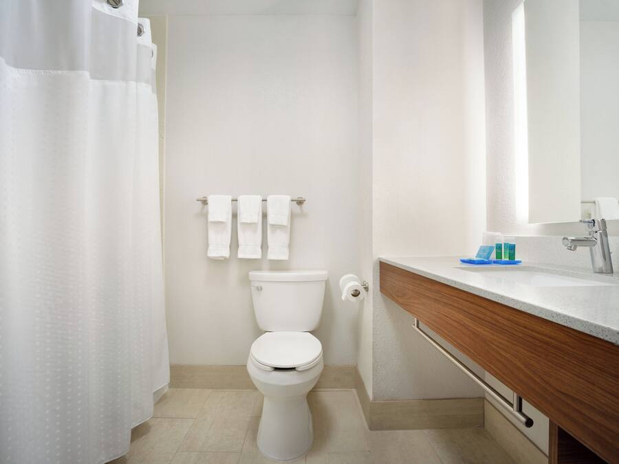 A modern bathroom with a toilet, a sink, and a shower curtain.