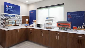 A breakfast area with a bakery display, a toaster, and a sign explaining the breakfast process.