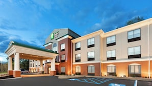 Ein Holiday Inn Express Gebäude mit überdachter Parkfläche und Parkplätzen für Menschen mit Behinderung.