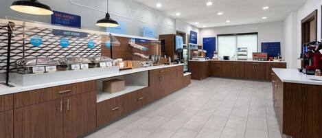 Una cocina moderna con armarios de madera, encimera blanca y diversos alimentos.