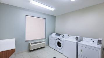 Un lavadero con lavadora, secadora y conducto de ventilación.