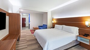 A hotel room with a large bed, a TV, a desk, and a chair. - Holiday Inn Express Hotel & Suites Orange by IHG (Orange)