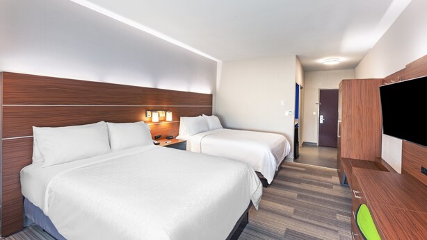 A hotel room with two beds, a TV, and a desk. - Holiday Inn Express Hotel & Suites Orange by IHG (Orange)