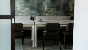 A dining area with a table, chairs, and a bowl of fruit. - The Harborvale, Autograph Collection (Burlington)