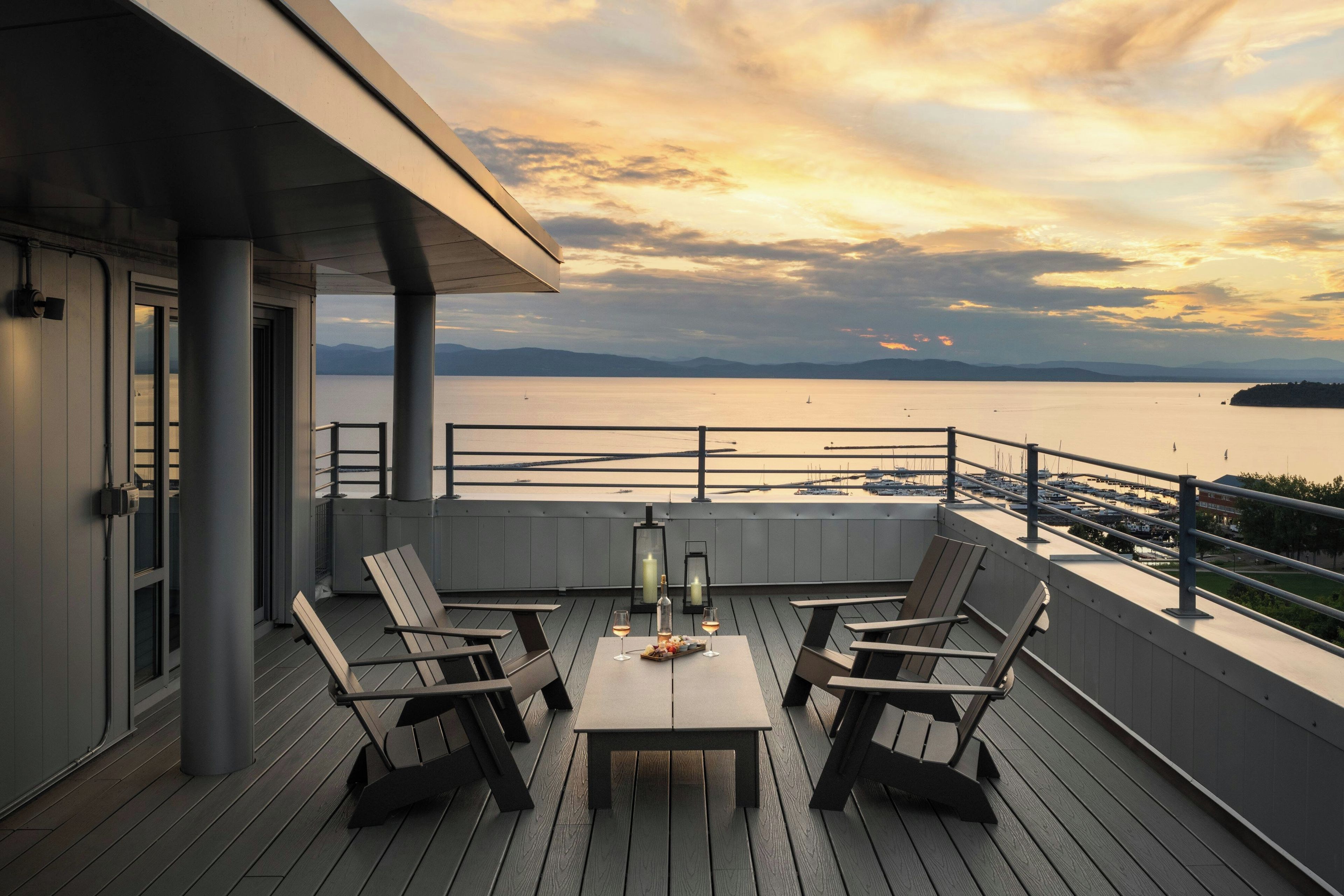 A deck with outdoor seating and a view of a marina.