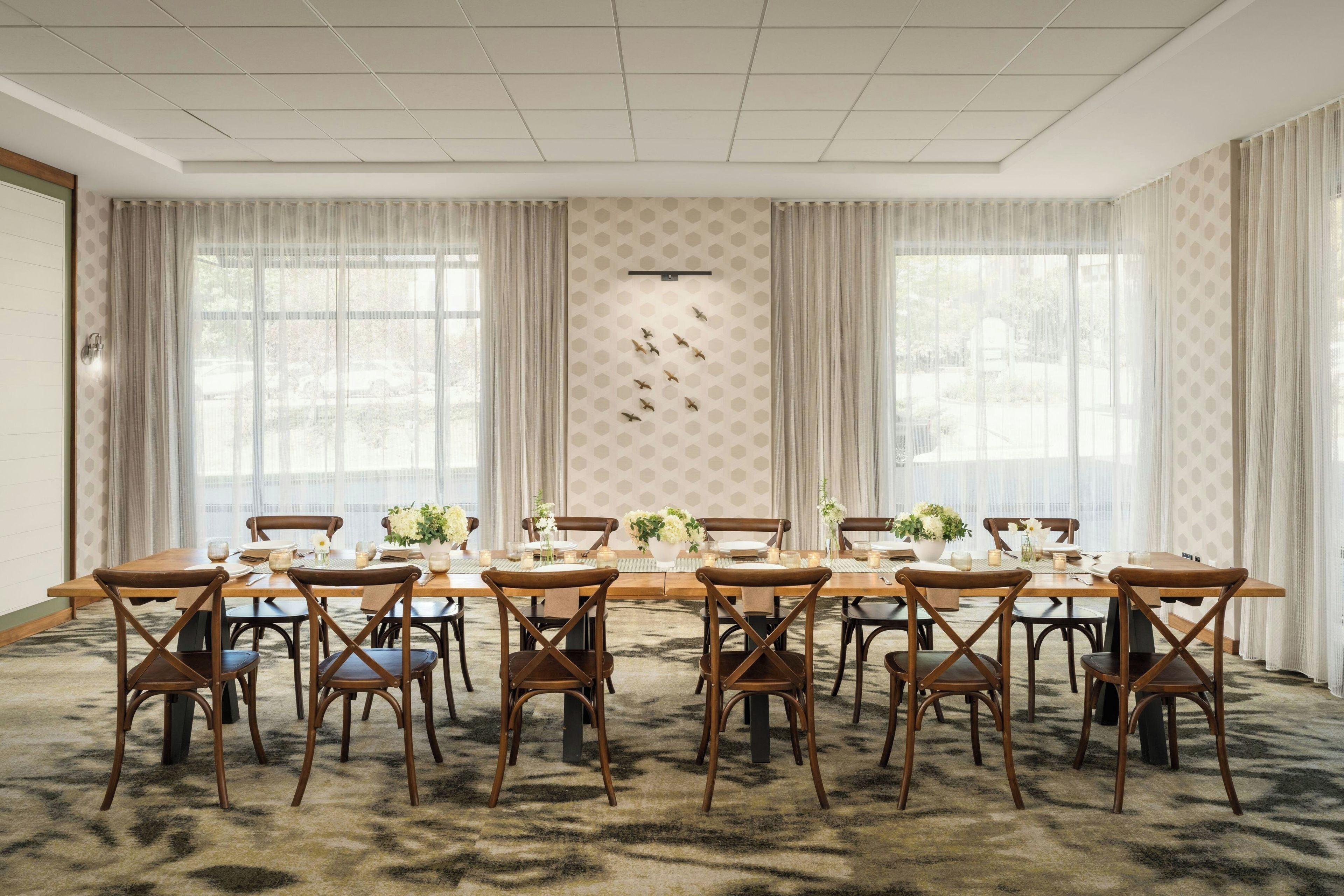 A conference room with a long table, chairs, and a patterned wall.