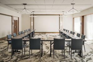 A conference room with a long table, chairs, and overhead lighting. - The Harborvale, Autograph Collection (Burlington)