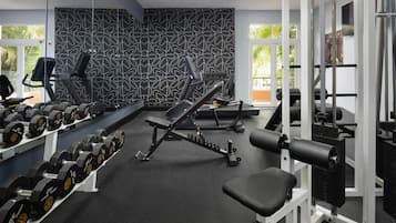 Una palestra con attrezzature per esercizi, manubri e una panca.